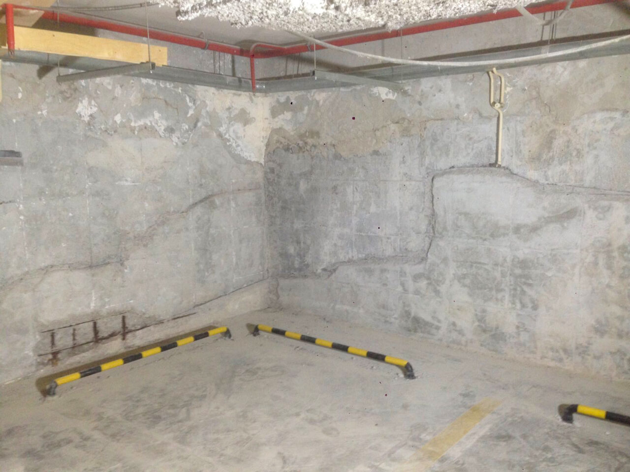 Фото частини підземного паркінгу з пошкодженими стінами та стелею