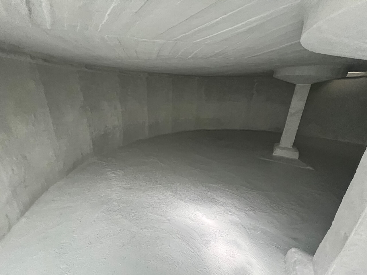 Фото бетонного резервуару зсередини з нанесеною гідроізоляцією білого кольору на стіни, підлогу та стелю